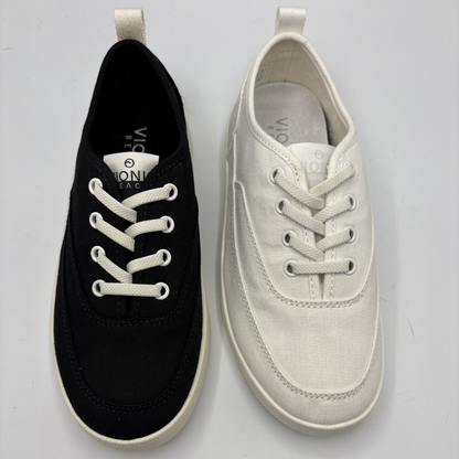 Black and white sneakers with visible brand logo on a light gray background