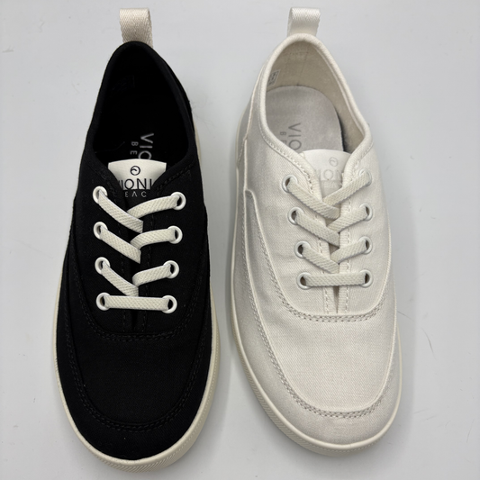 Black and white sneakers with visible brand logo on a light gray background