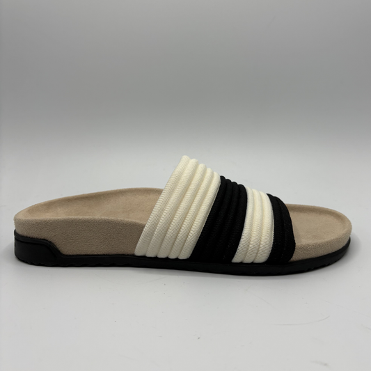 Beige sandal with black and white straps on a gray background
