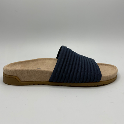 Navy slipper with a beige sole on a gray background