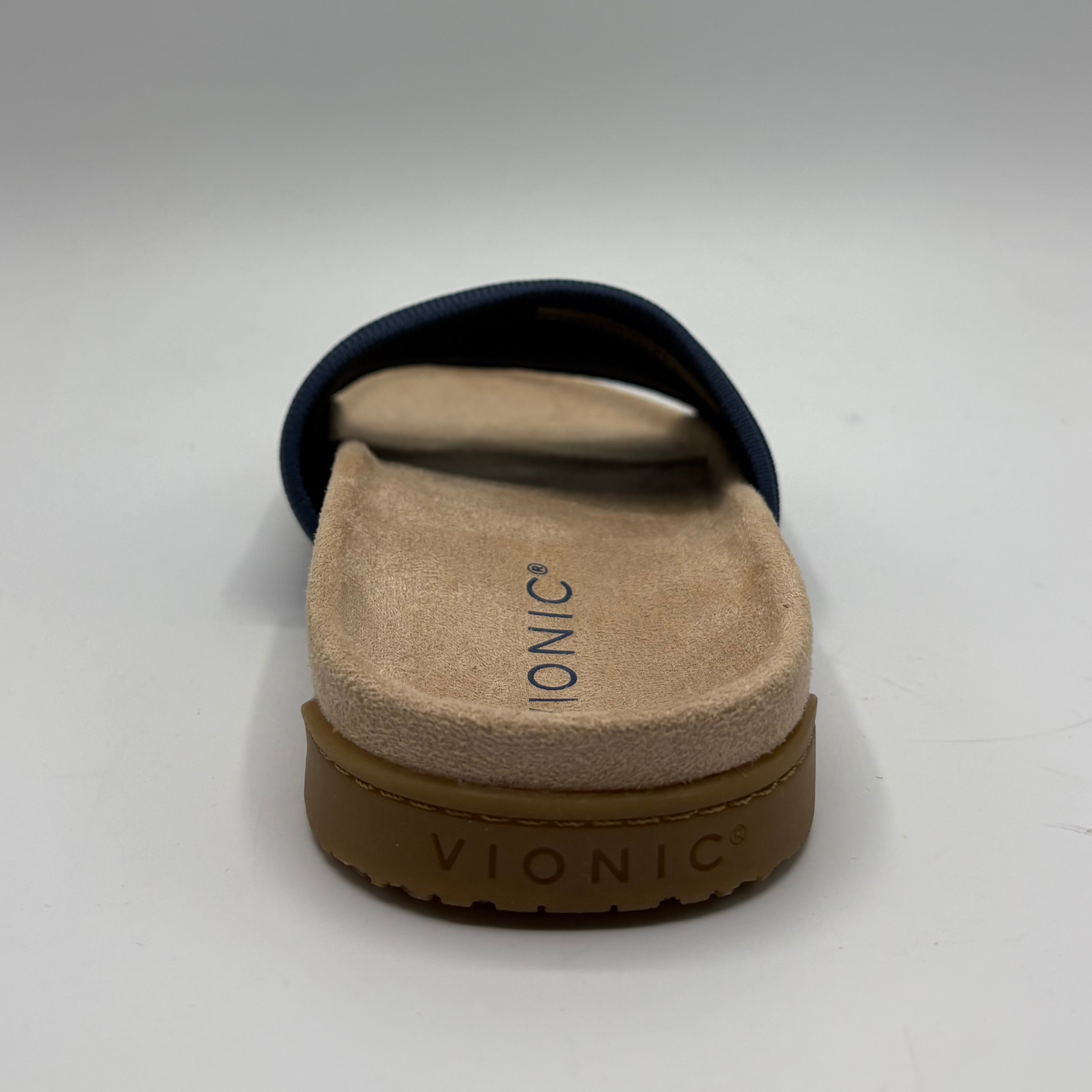 Vionic sandal with brown sole and beige footbed on a white background