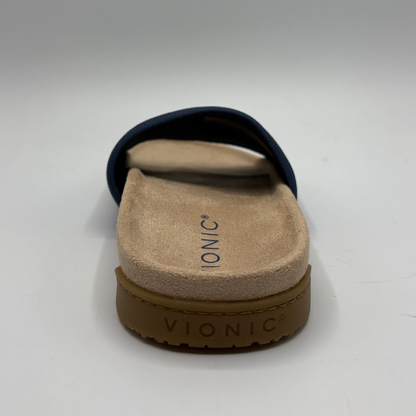 Vionic sandal with brown sole and beige footbed on a white background