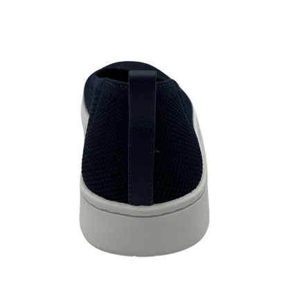 Back view of navy knit flat shoe with removable insole, rounded toe and pull on heel tab.