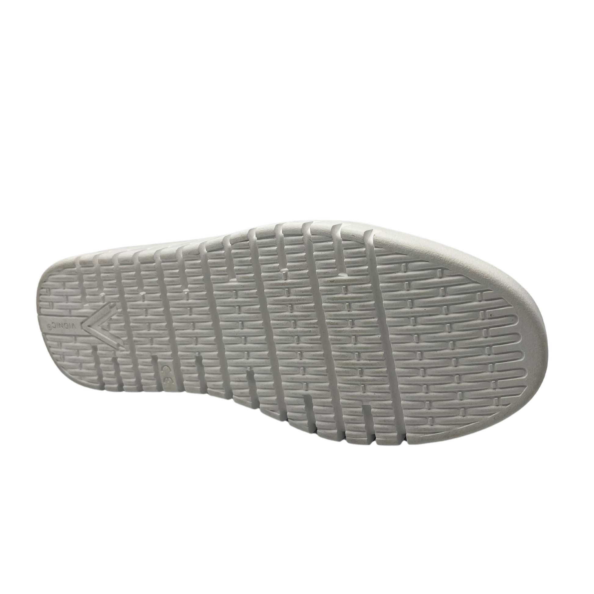 Bottom view of navy knit flat shoe with removable insole, rounded toe and pull on heel tab.