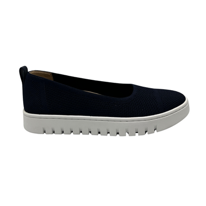 Right facing view of navy knit flat shoe with removable insole, rounded toe and pull on heel tab.