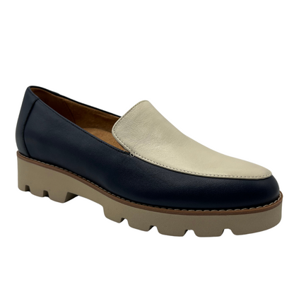 45 degree angled view of navy and cream leather loafer with chunky sole