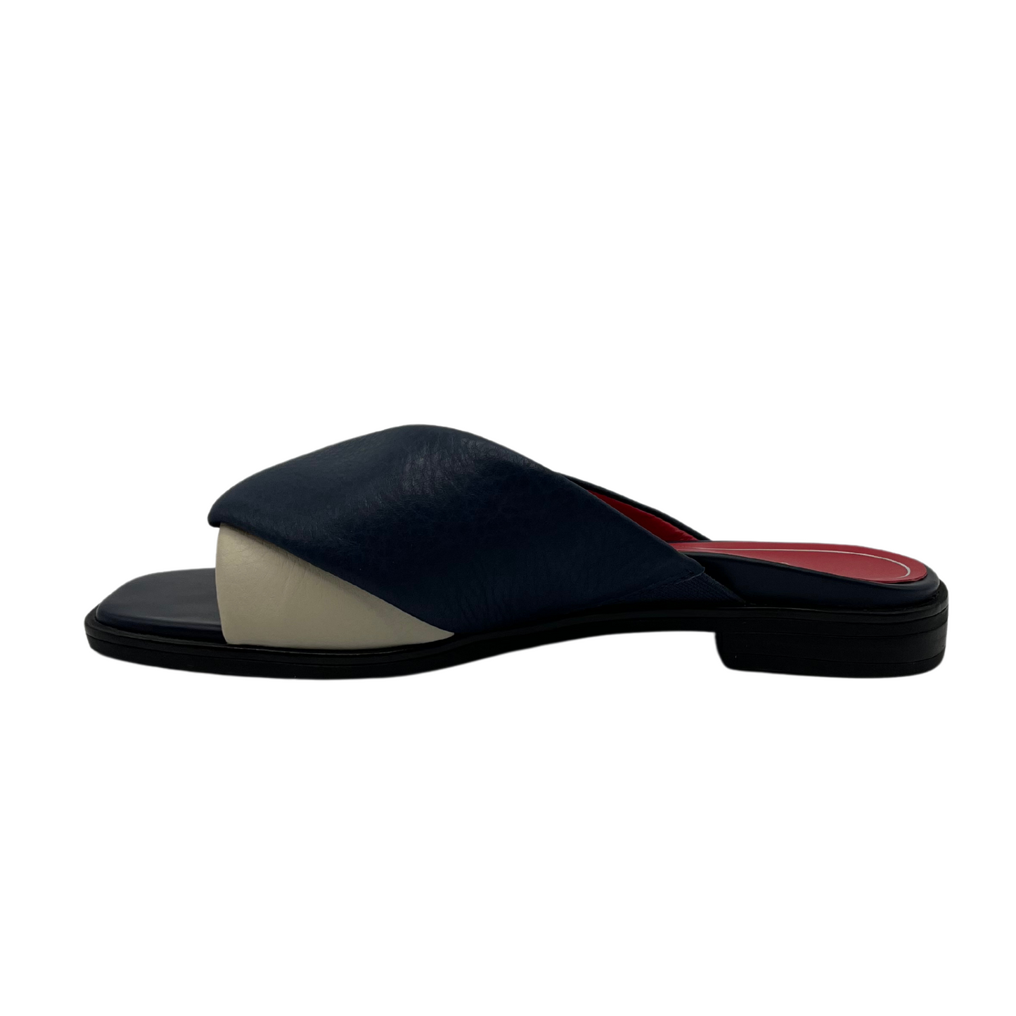 Left facing view of navy and cream leather slip on with square toe and red inner lining