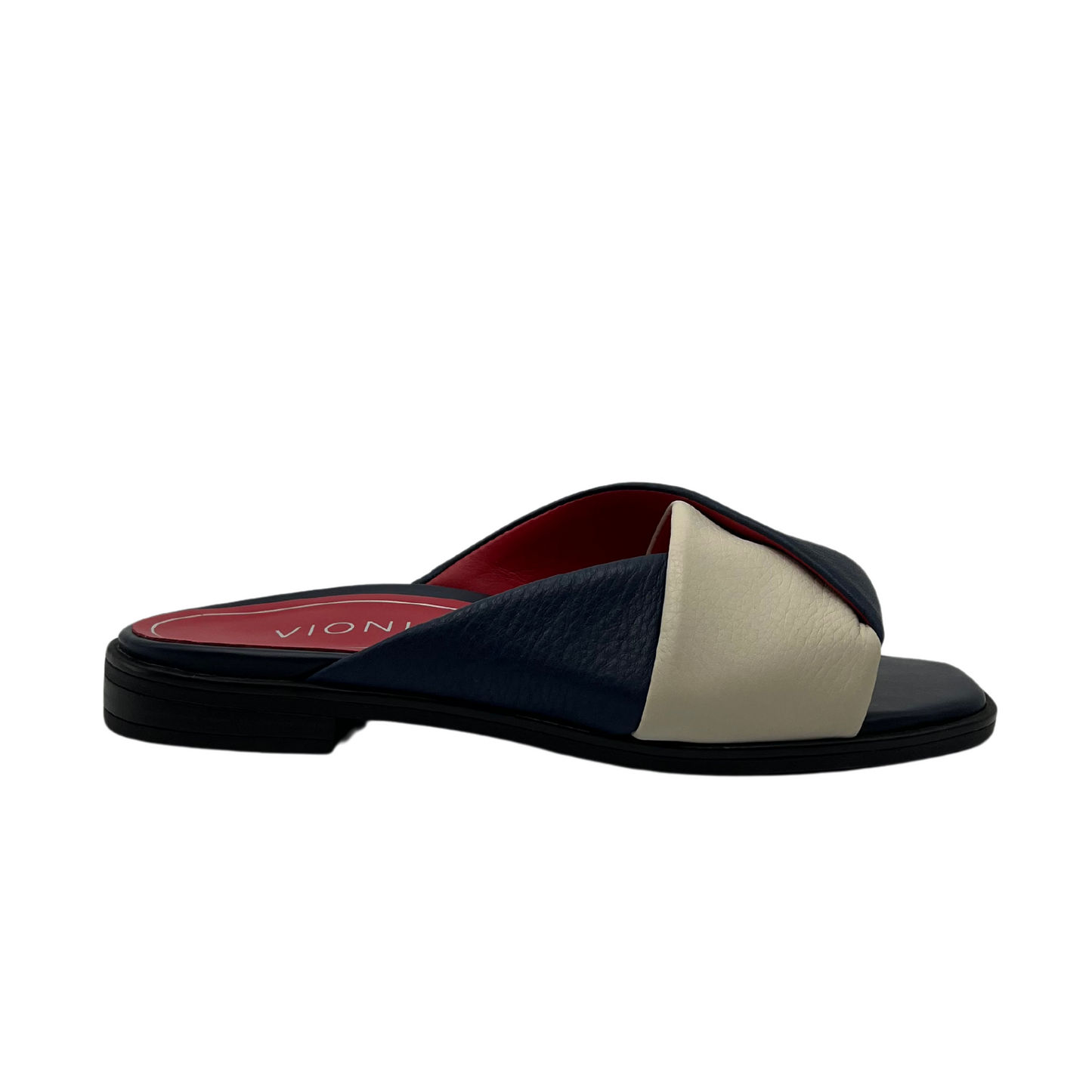Right facing view of navy and cream leather slip on sandal with red inner lining