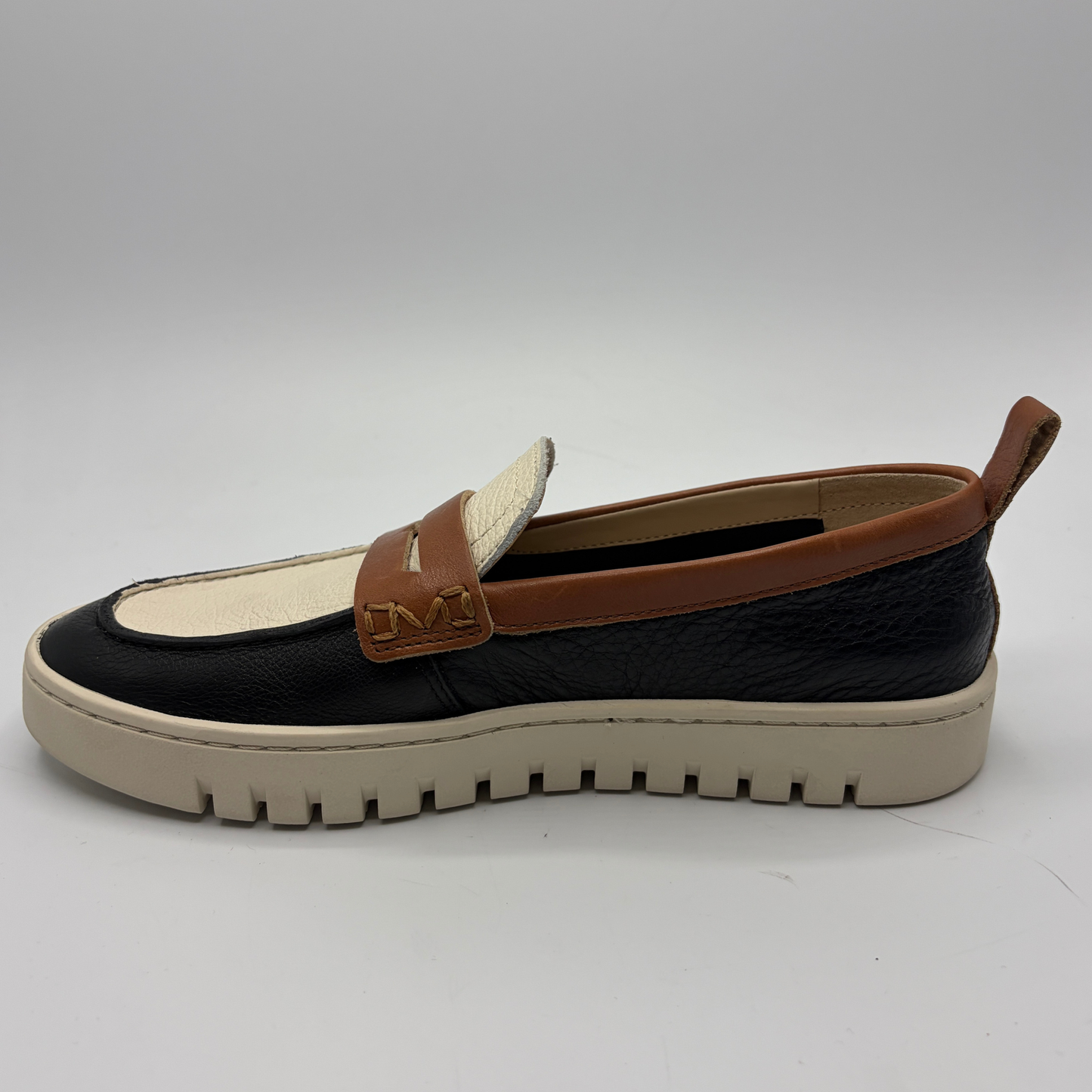 Loafer shoe with brown strap on a white background