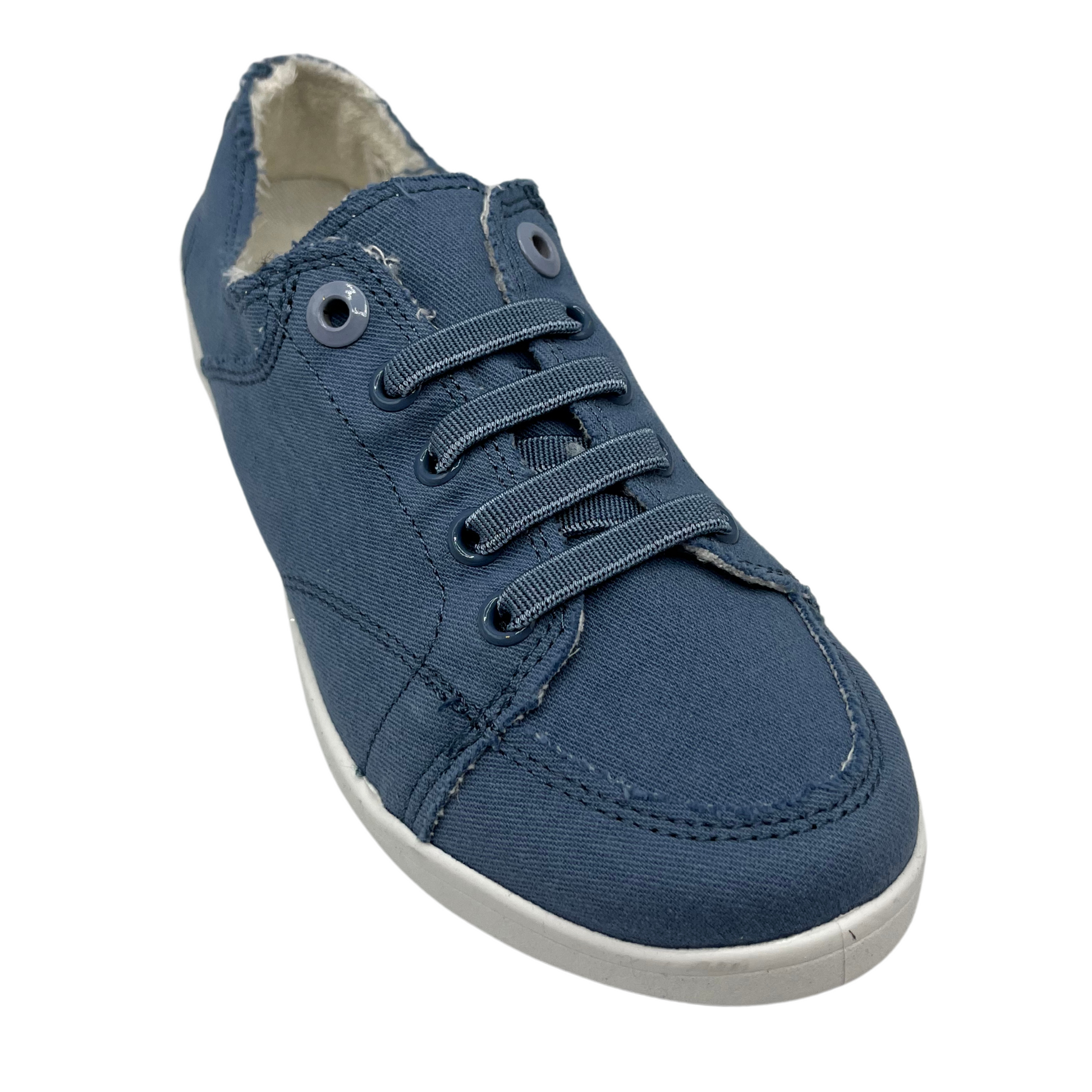 45 degree angled view of blue canvas sneaker with white rubber outsole