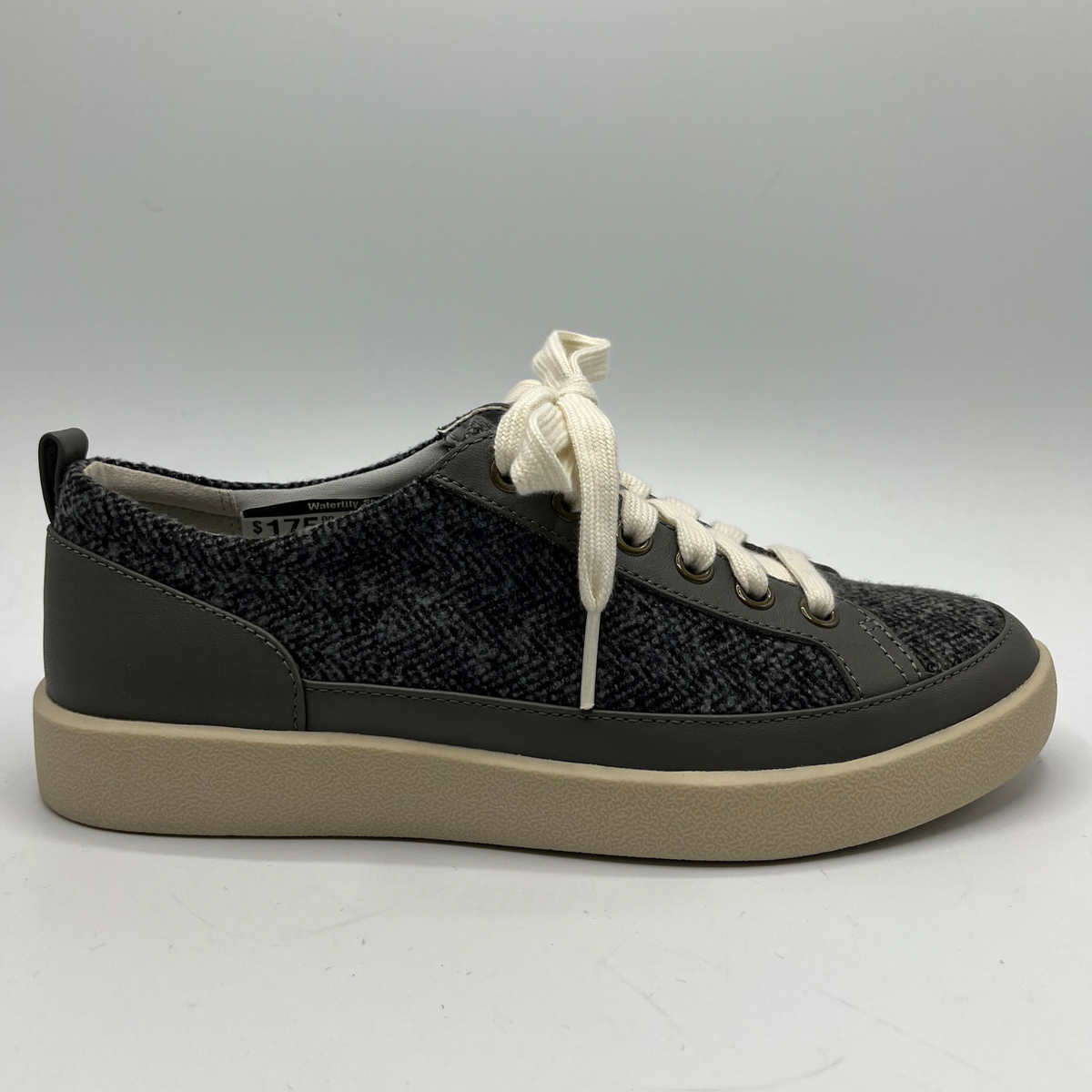 Grey sneaker with white laces on a gray background