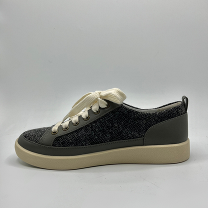 Grey sneaker with white laces on a gray background