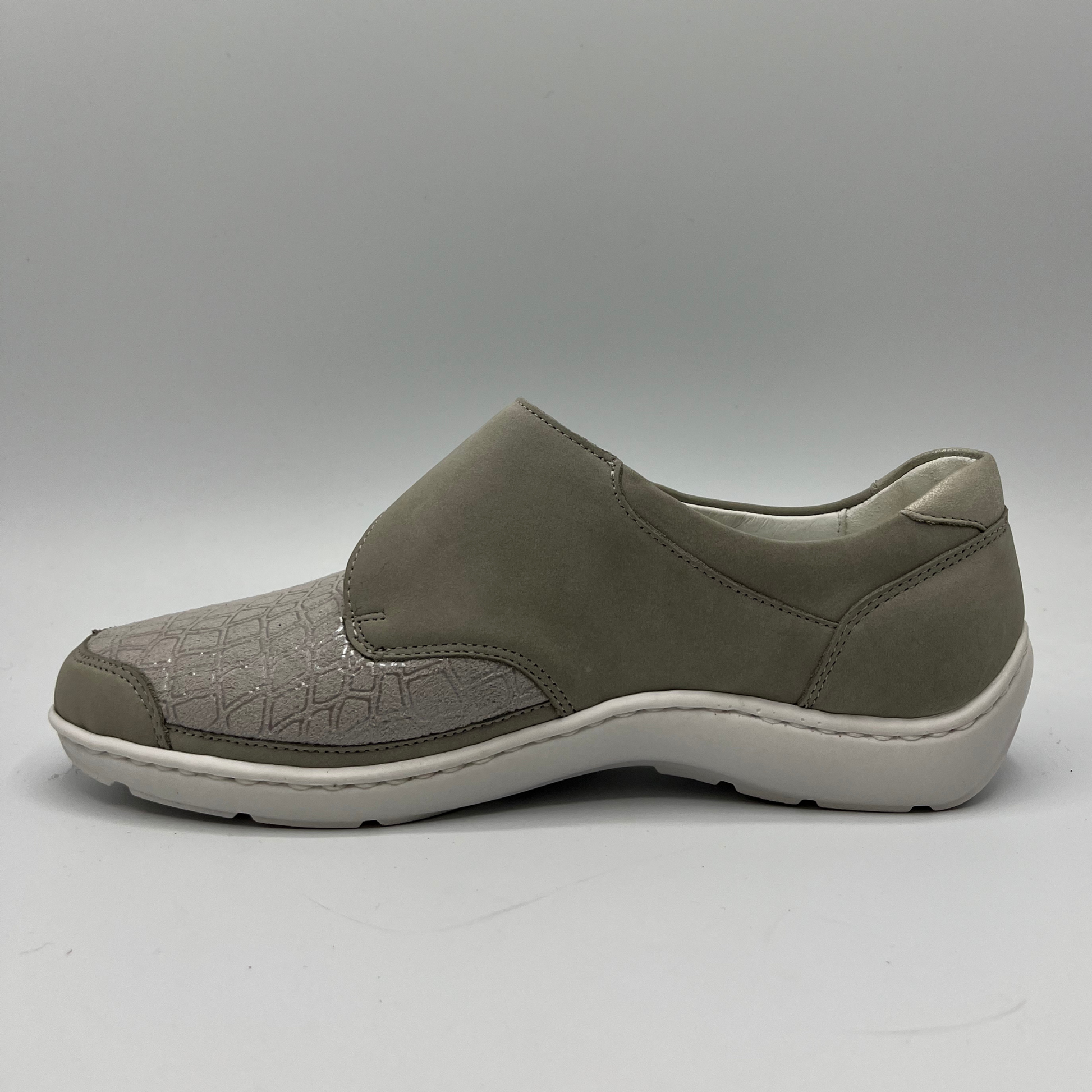 Left facing view of a grey sneaker with a velcro strap and a contoured footbed.
