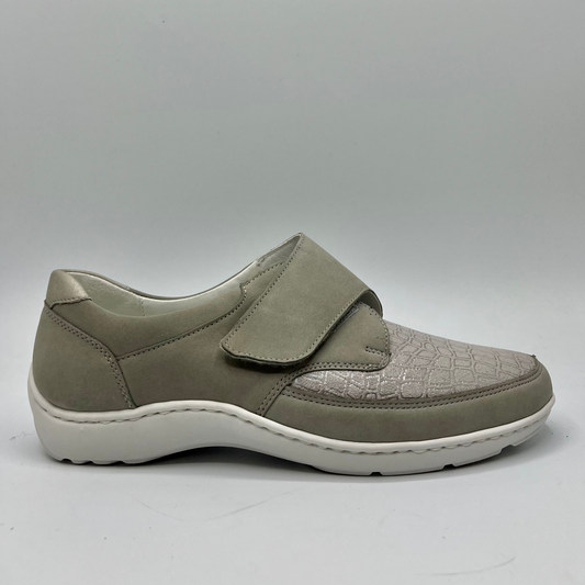 Right facing view of a grey sneaker with a velcro strap and a contoured footbed.
