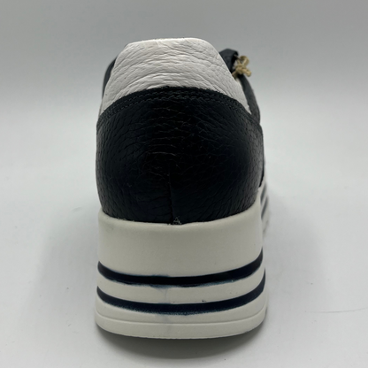 Back view of a navy leather sneaker with a white rubber outsole with laces and a side zipper closure.