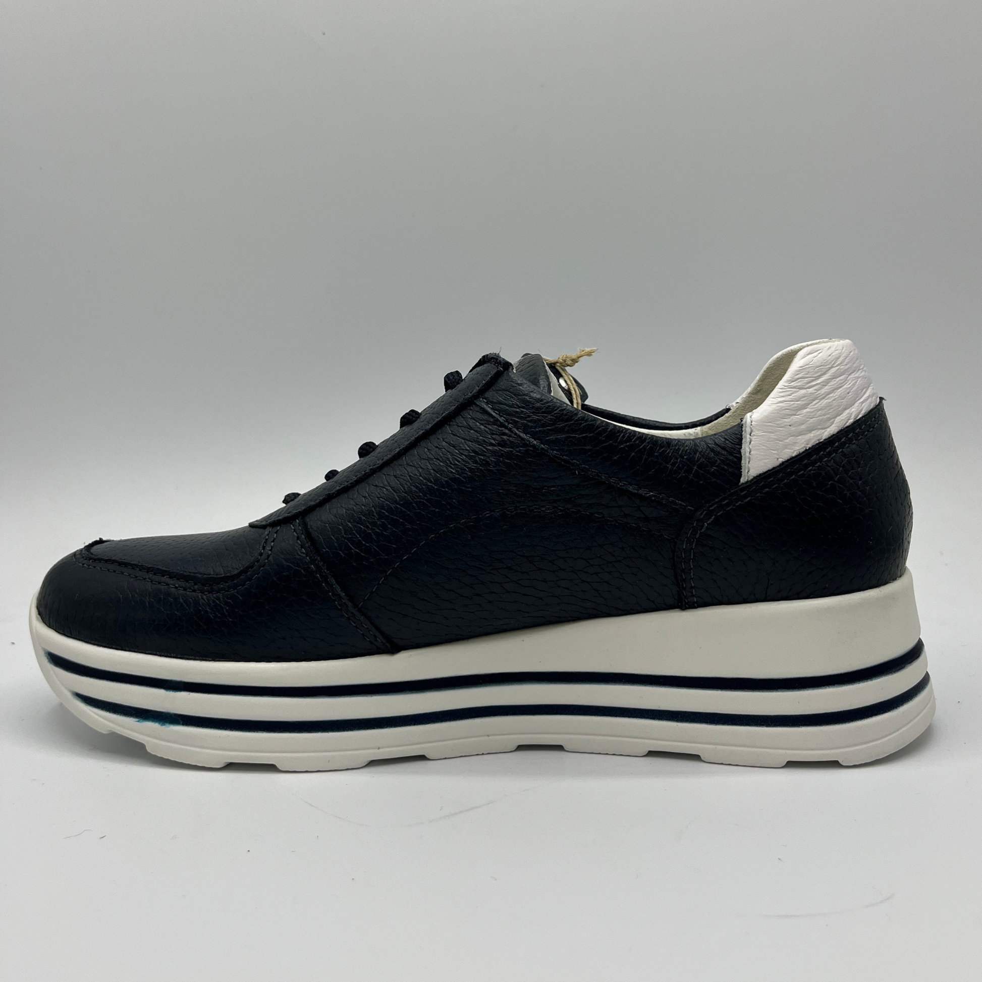 Left facing view of a navy leather sneaker with a white rubber outsole with laces and a side zipper closure.