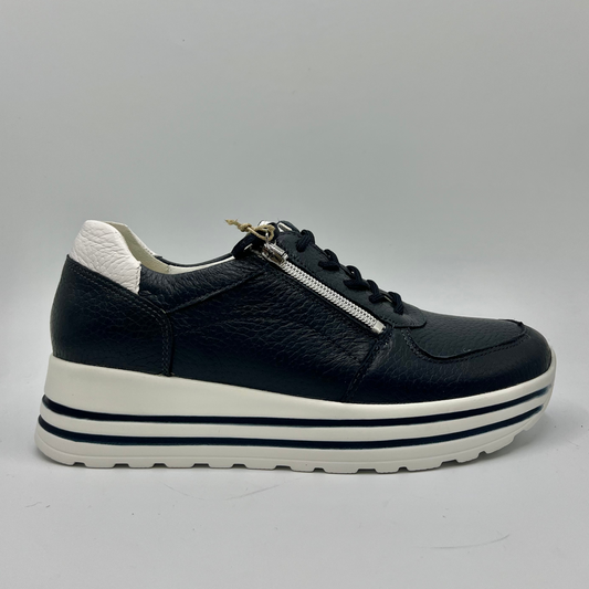 Right facing view of a navy leather sneaker with a white rubber outsole with laces and a side zipper closure.