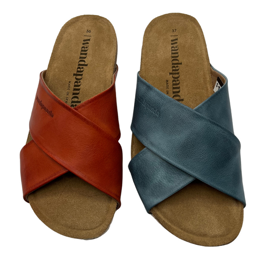 Top view of two leather sandals beside each other. Left one has red leather straps and the right one is blue leather straps