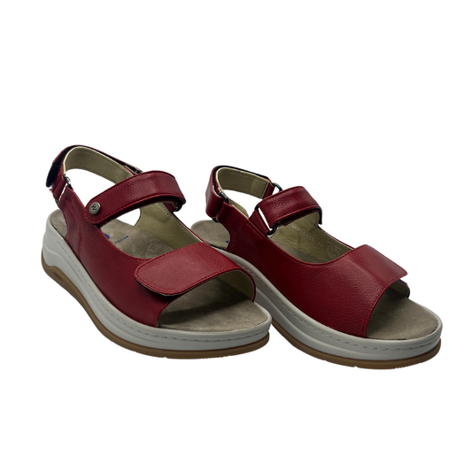 45 degree angled view of red vegan leather sandals with adjustable velcro straps and thick supportive sole