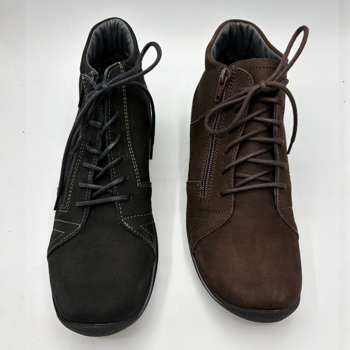 Top view of a pair of ankle boots beside eachother. One is black and the other is brown