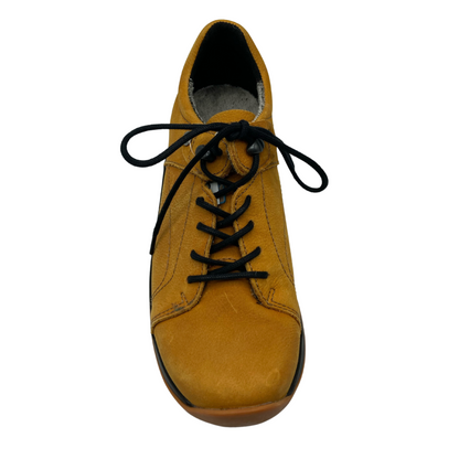 Top view of yellow nubuck sneaker with black laces and rounded toe