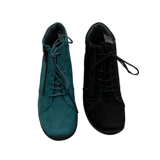 Top view of two lace up short boots side by side. One is teal suede and the other is black suede. Both have matching laces and a rounded toe.
