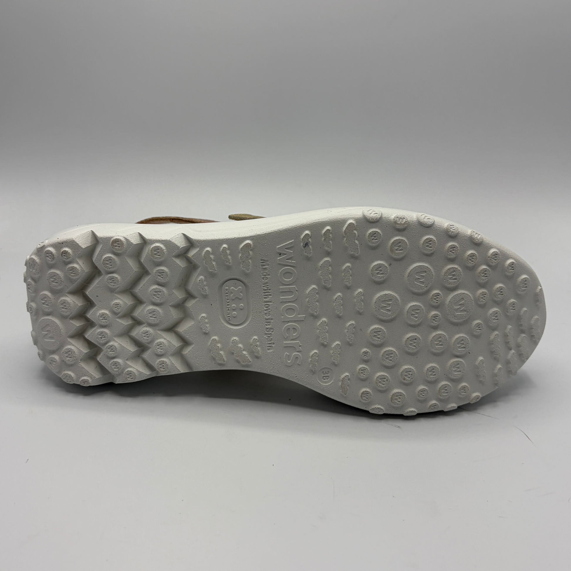 Close-up of a shoe sole with brand logo on a gray background