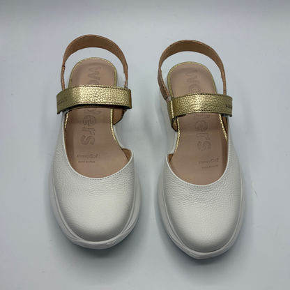 Pair of white shoes with gold straps on a light gray background