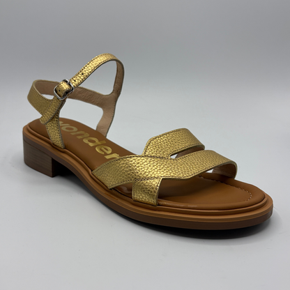 Gold sandal with brown sole on a gray background