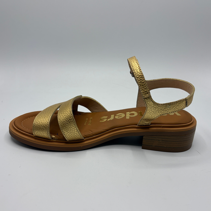 Gold sandal with brown sole on a white background