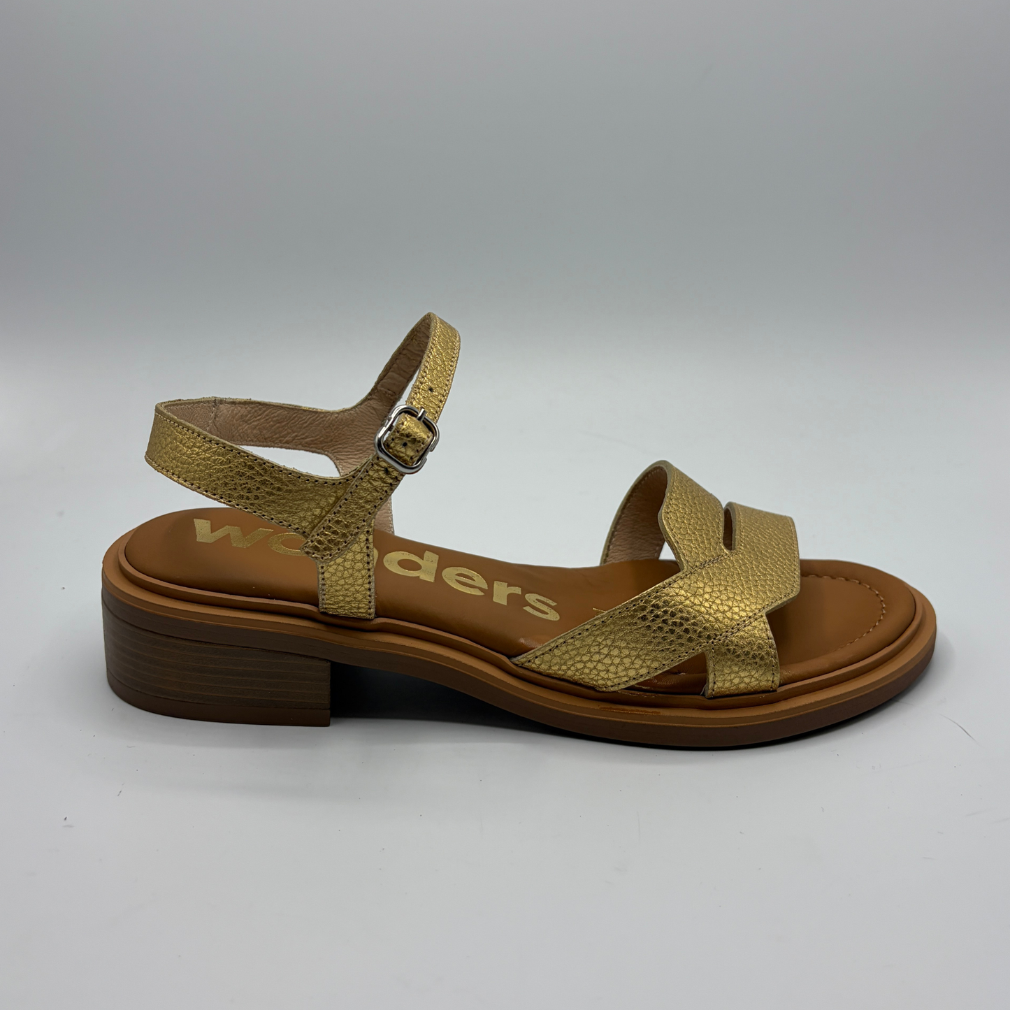 Gold sandal with brown sole on a white background