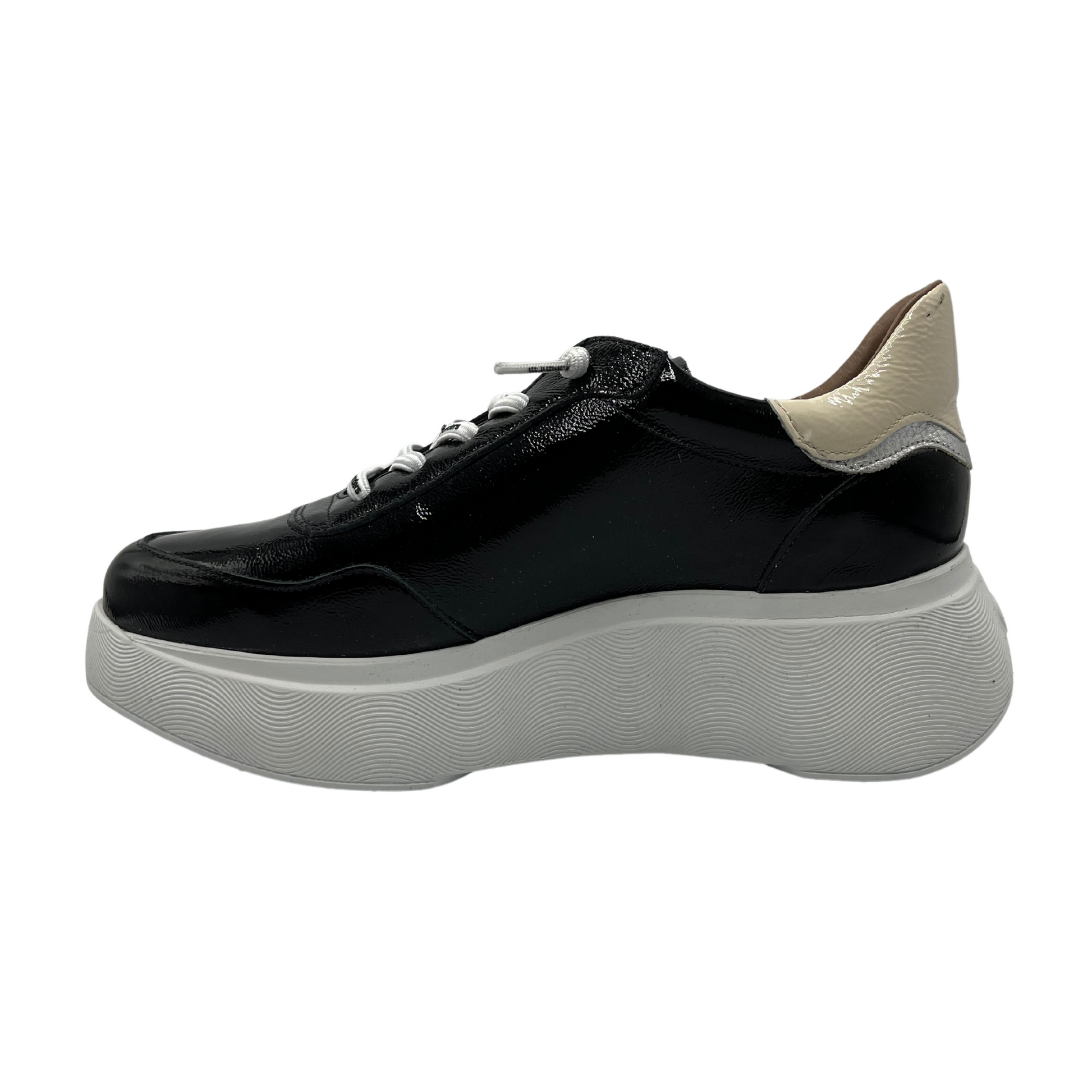 Left facing view of black patent leather sneaker with a padded heel and platform sole