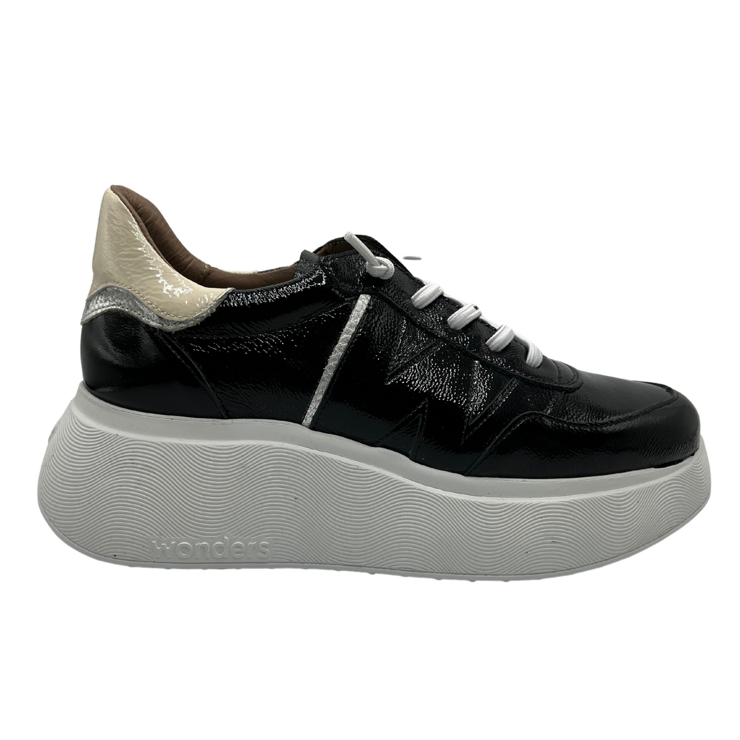 Right facing view of black patent leather sneaker with a padded heel and platform sole