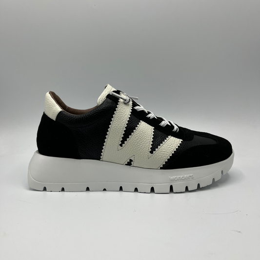 Right facing view of leather sneaker with a lightweight white outsole. Leather upper is black and white.