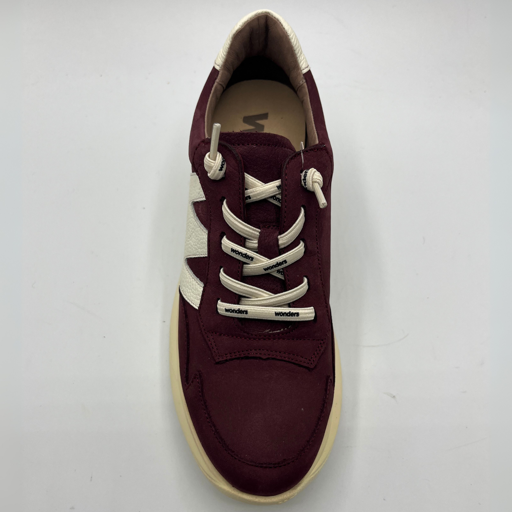 Maroon sneaker with white laces on a light gray background