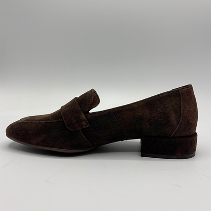 A single dark brown suede penny loafer with a low block heel, shown in a side profile against a neutral gray background.