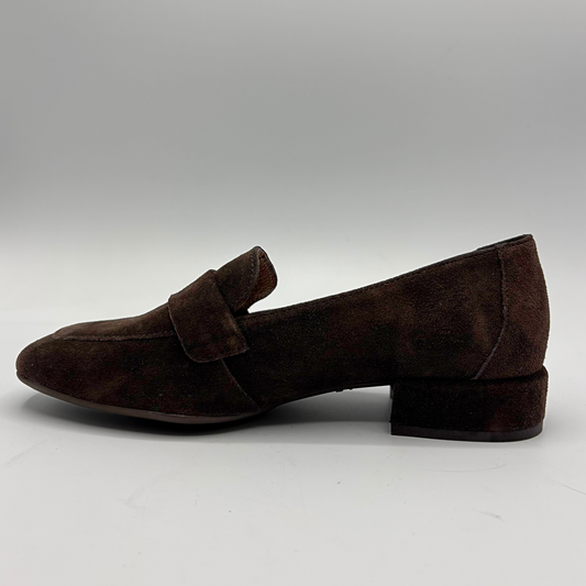 A single dark brown suede penny loafer with a low block heel, shown in a side profile against a neutral gray background.