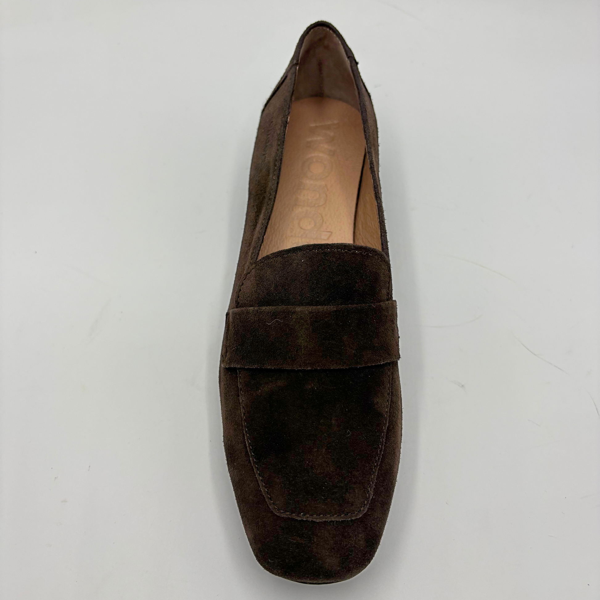 Top view of a brown suede loafer on a grey background