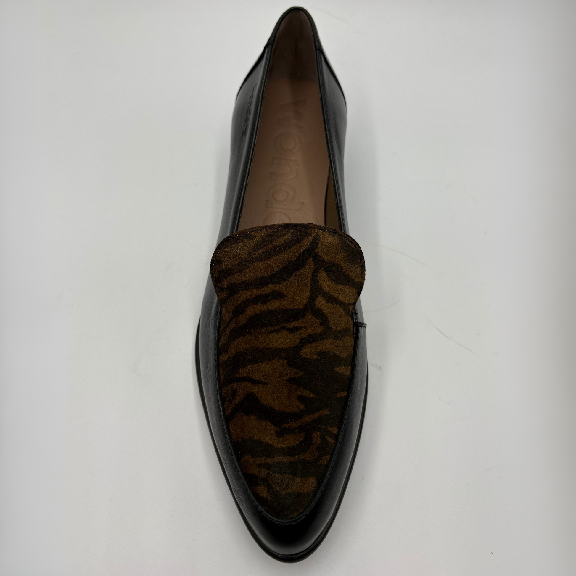 A single black leather loafer with a brown and black tiger-stripe patterned suede vamp, photographed from a top-down angle on a light gray background.