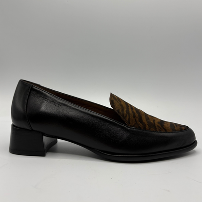 A black leather loafer with a brown and black zebra-patterned fabric accent on the vamp, shown from a side profile against a neutral gray background.