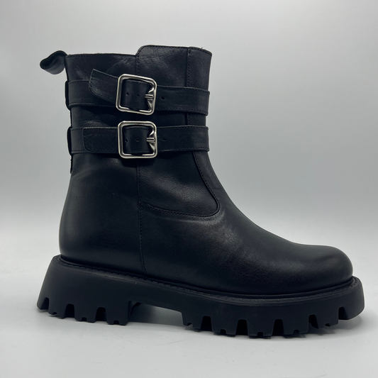Black boot with silver buckles on a gray background