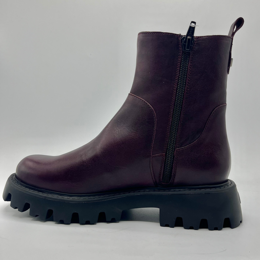 Purple boot with a black sole on a white background