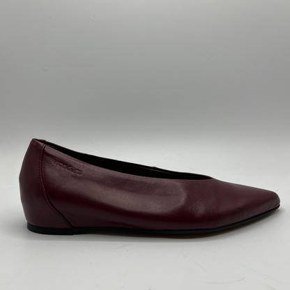 Burgundy leather flat shoe on a gray background
