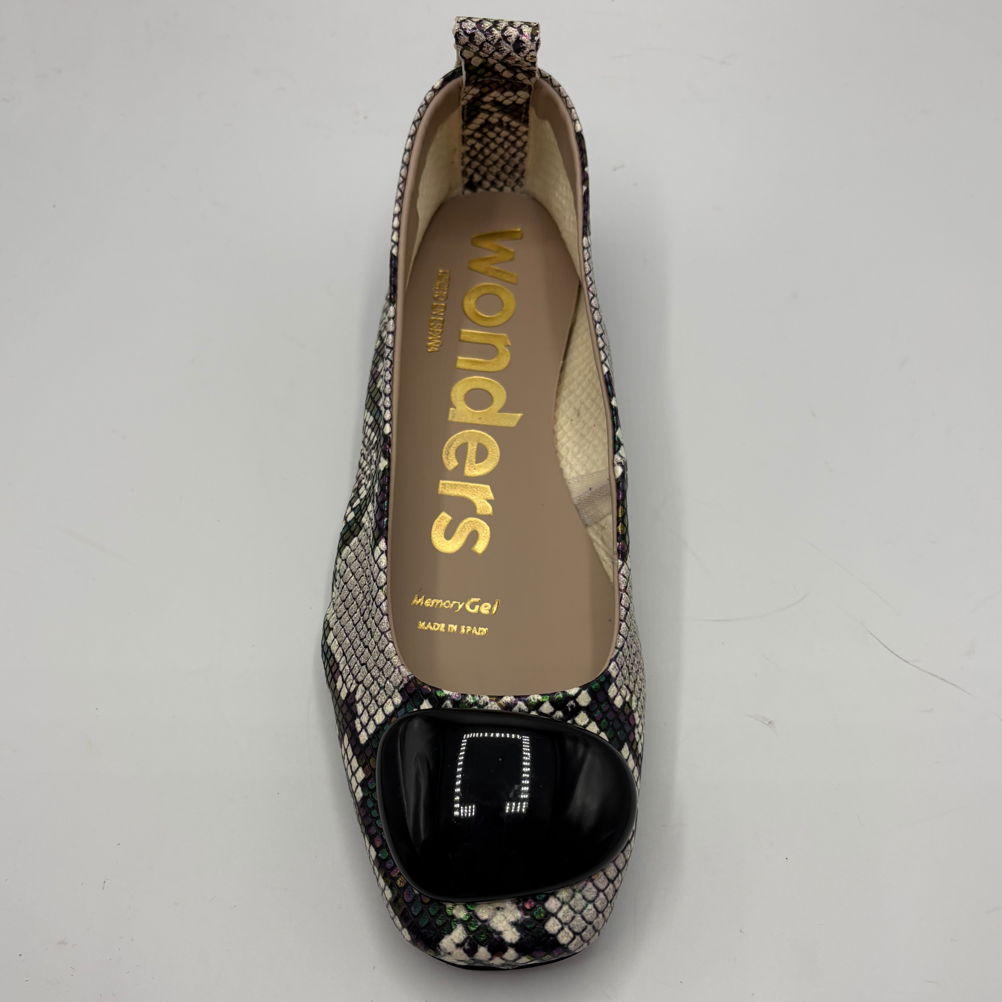Patterned flat shoe with 'wonders' branding on a gray background