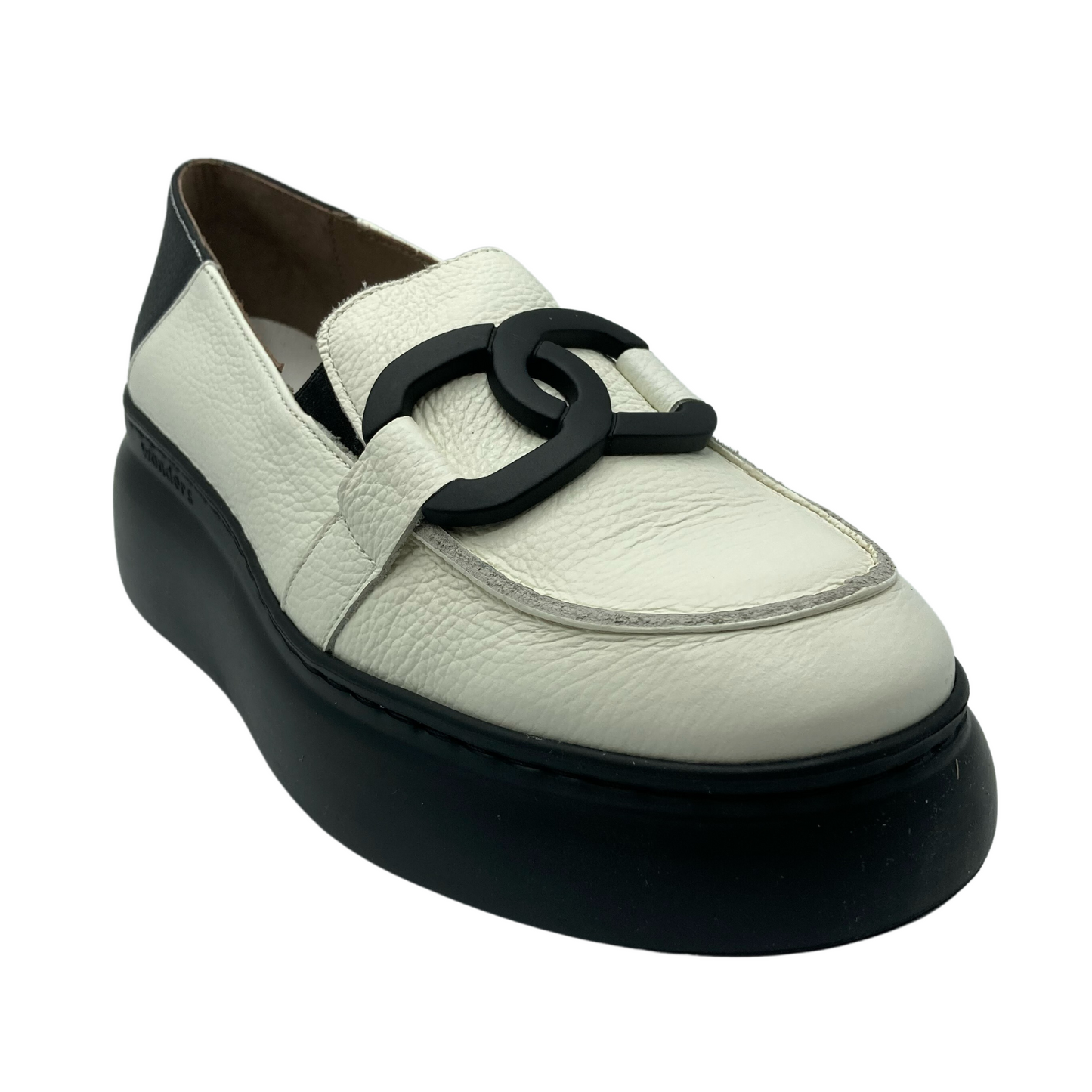 Angled view of white leather loafer with black buckled detail and black sole