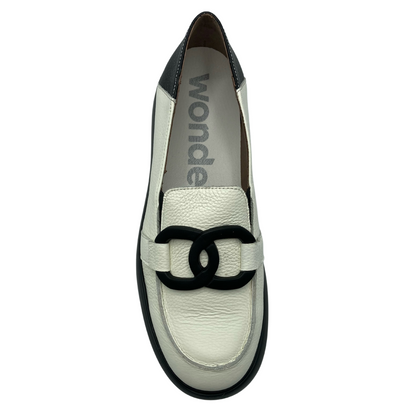 Top down view of white leather loafer with black buckle detail on the upper and black detail on the heel