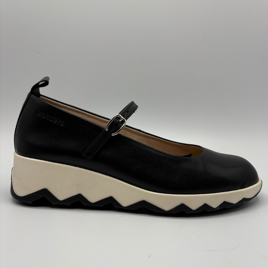 Black shoe with a white sole on a gray background