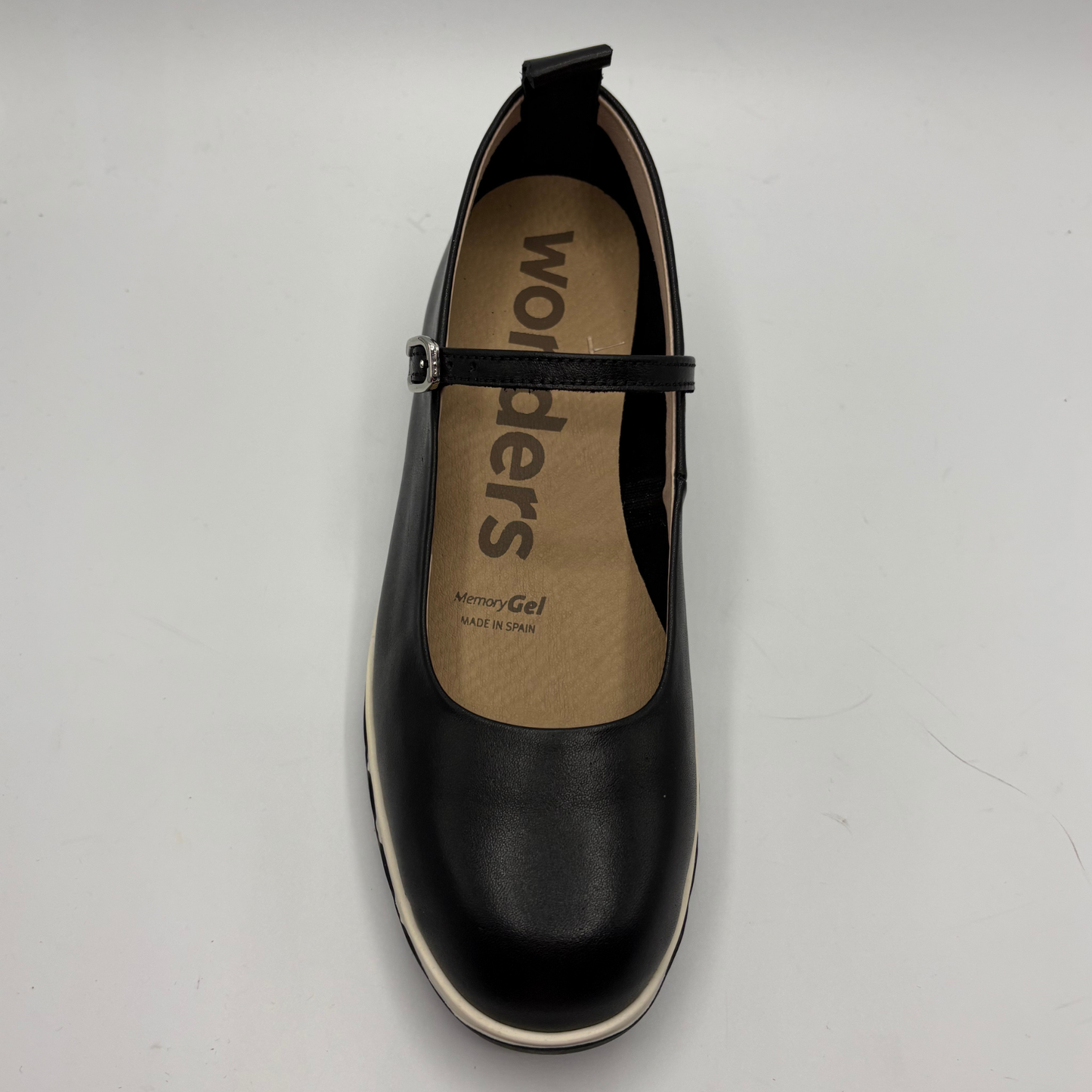 Black shoe with 'wonders' branding on a gray background