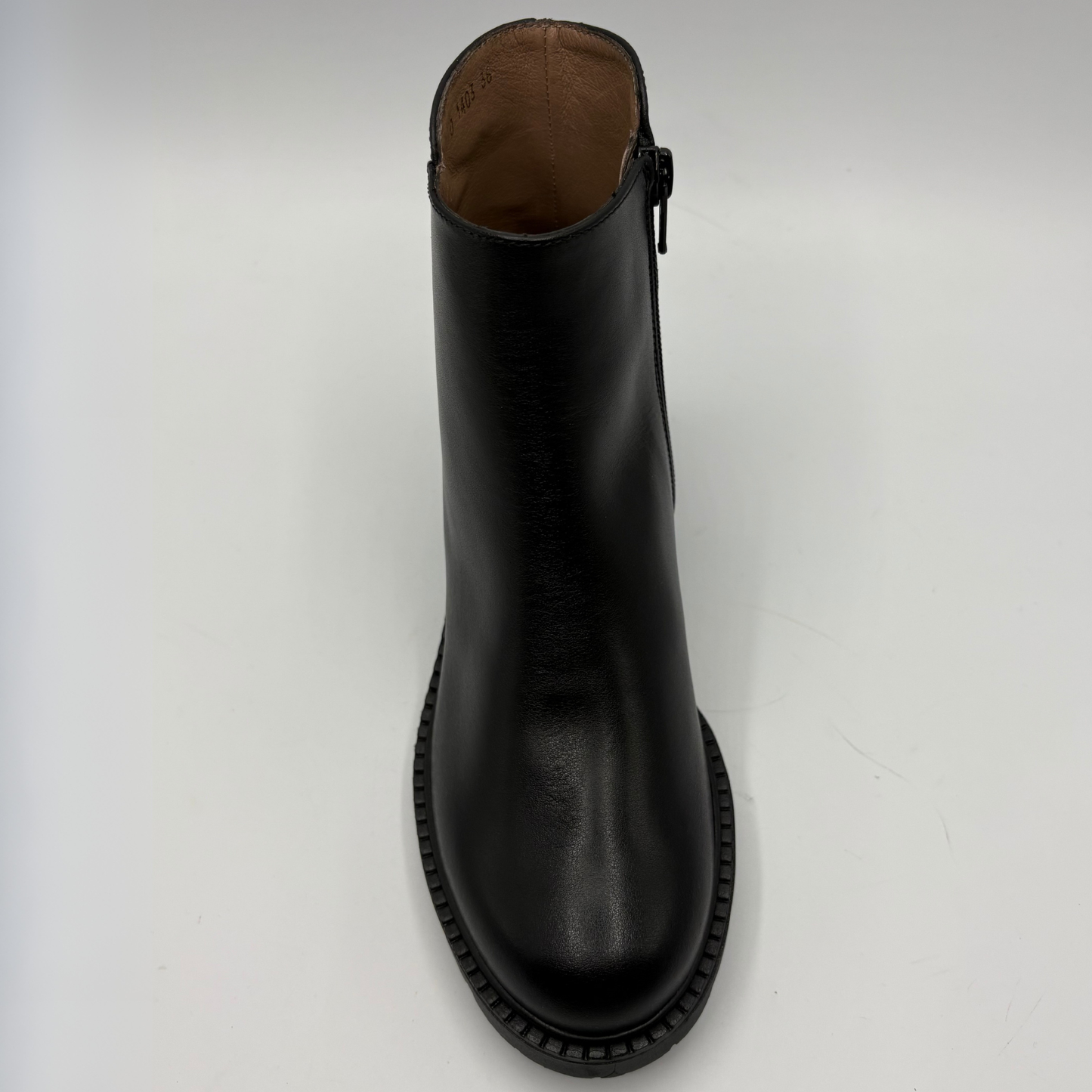 A black leather ankle boot with a side zipper, shown from a top-down perspective on a light gray background.