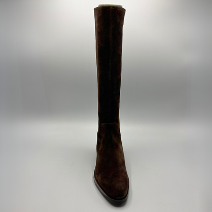 A single dark brown suede knee-high boot with a pointed toe and low block heel, photographed against a neutral gray studio background.